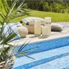 Three LED candles of varying heights are placed on a wooden deck next to a swimming pool, with a grassy hill and trees in the background. Podgląd zdjęcia produktu