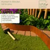 A garden border made of Corten steel is being installed in a garden bed, with a mallet nearby. Produktbild-Vorschau