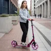 A young person rides a scooter on a city sidewalk. Voir les images du produit
