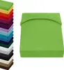 A stack of colorful fitted sheets is shown on the left, with a single green fitted sheet prominently displayed on the right. Produktbild-Vorschau
