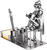 A metal desk organizer with a pen holder and a figurine of a veterinarian examining a patient. Náhľad obrázku produktu
