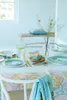 A table setting with plates, glasses, and a vase of flowers. Produktbild-Vorschau