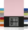 A collection of fabric swatches in various colors, with a large pink swatch dominating the top half of the image. A black rectangle with a white logo is centered at the bottom. Produktbild-Vorschau