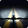 Riding a bicycle at night on a road with yellow lines, illuminated by the bicycle's headlights. Podgląd zdjęcia produktu