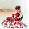 A young boy is playing with a toy fire station playset on the floor. Produktbild-Vorschau