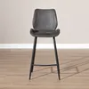 A single bar stool is shown from the front, centered in the frame. The stool has a dark gray seat and backrest, and black metal legs. It is placed on a light wood-look floor against a plain, light gray wall with a white baseboard. Produktbild-Vorschau