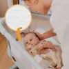 A mother is looking at her baby in a bedside crib. A close-up inset shows the texture of the mattress. Anteprima dell’immagine prodotto