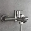 A close-up shot of a brushed nickel shower faucet mounted on a gray tiled wall. Produktbild-Vorschau