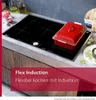 A modern kitchen induction cooktop with a red pot on it. Podgląd zdjęcia produktu