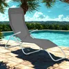 A gray lounge chair is placed on a tiled patio next to a swimming pool, with palm trees and lush greenery in the background under a clear blue sky. Produktbild-Vorschau