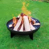 A fire pit with burning logs on a grassy lawn. Produktbild-Vorschau