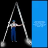 A man in blue overalls stands between the two extended legs of a large, silver, multi-purpose ladder. Text describing the ladder's specifications is on the right side of the image. Podgląd zdjęcia produktu