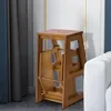 A wooden step stool is shown in a room next to a white sofa and grey curtains. Podgląd zdjęcia produktu
