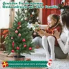 A mother and daughter are sitting on the floor next to a small Christmas tree, with the daughter holding a gift. Produktbild-Vorschau