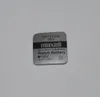 A single silver coin cell battery with text and a logo printed on it, placed on a white background. Produktbild-Vorschau