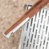 Close-up of tongs resting on a grill grate. Produktbild-Vorschau