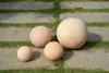 Four terracotta garden spheres of varying sizes are arranged on a paved pathway with grass in between. Náhľad obrázku produktu