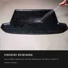 A black car trunk liner is being sprayed with water to demonstrate its easy cleaning. Produktbild-Vorschau