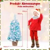 A child dressed as Santa Claus stands next to a small, blue, snow-covered Christmas tree, with measurement indicators. Podgląd zdjęcia produktu