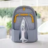 A compact ironing board with an iron stored inside, set on a white surface with a blurred outdoor background. Náhľad obrázku produktu