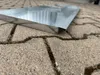 A close-up of a metal tray on a paved surface. Produktbild-Vorschau