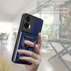 A hand holding a blue phone case with a ring holder, with a blurred indoor background. Produktbild-Vorschau