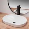 A white oval sink with a black faucet is shown on a wooden surface, with a round mirror in the background. Produktbild-Vorschau
