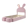 A pink upholstered bed frame with rabbit ears and two storage ottomans at the foot of the bed, set against a white background. Anteprima dell’immagine prodotto