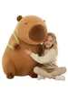 A young girl is hugging a large plush capybara toy. Produktbild-Vorschau