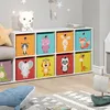 A white storage unit with colorful fabric bins featuring animal designs, in a child's room. Produktbild-Vorschau