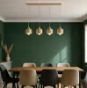 A dining room with a table and chairs under a modern pendant light fixture. Produktbild-Vorschau