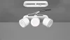 A white ceiling light fixture with three adjustable spotlights is shown against a gray ceiling. Produktbild-Vorschau