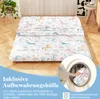 A futon mattress with a unicorn and rainbow pattern is laid out on a wooden floor, with a washing machine drum visible in the lower right corner. Náhled obrázku produktu