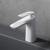 A white faucet is shown on a gray countertop against a gray textured wall. Anteprima dell’immagine prodotto