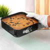 A hand wearing a baking glove is holding a square cake pan with a freshly baked cake inside. Náhľad obrázku produktu