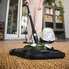 A person is using a steam cleaner on a rug indoors, with a cabinet and door in the background. Anteprima dell’immagine prodotto