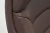 A close-up view of the stitching and texture of a brown leather office chair. Produktbild-Vorschau