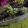 A close-up view of a garden bed with metal edging, showing plants and soil. Produktbild-Vorschau