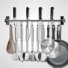 A set of kitchen utensils hanging on a rack mounted on a wall. Produktbild-Vorschau