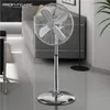 A chrome stand fan is shown in a modern living room setting. Podgląd zdjęcia produktu