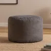 A grey corduroy ottoman sits on a tan rug. Produktbild-Vorschau
