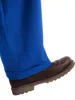 A close-up of a person's leg wearing blue pants and a brown shoe. Anteprima dell’immagine prodotto