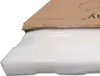 A close-up view of a product's packaging, showing a cardboard box partially open to reveal protective foam and plastic wrapping. Podgląd zdjęcia produktu