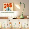 A desk with a lamp and a framed picture of flowers, with multiple views of the lamp shown below. Produktbild-Vorschau