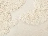 A close-up view of a textured beige fabric with a raised pattern. Produktbild-Vorschau