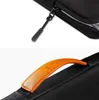 Close-up shots of a black laptop bag, showing a zipper pull and a leather handle. Anteprima dell’immagine prodotto