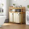 A bathroom scene with a bamboo laundry sorter, washing machine, and bathtub. Anteprima dell’immagine prodotto