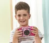 A young boy is holding a pink VTech Kidizoom Duo Pro camera. Produktbild-Vorschau