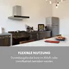 A modern kitchen with a stainless steel range hood, stove, and refrigerator. A table with fruit is in the foreground. Produktbild-Vorschau