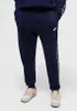 A person wearing navy blue Nike sweatpants and sneakers. Produktbild-Vorschau